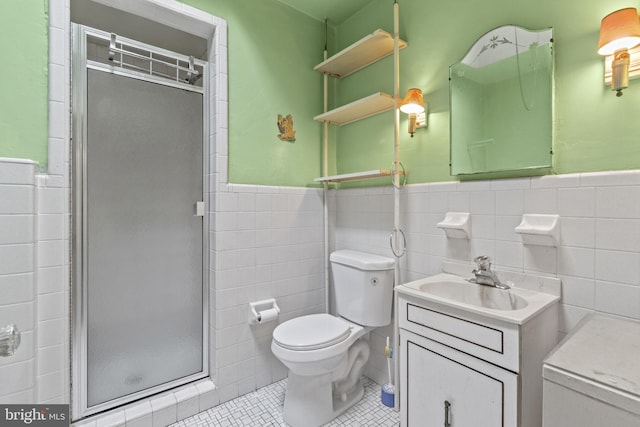 bathroom with walk in shower, tile patterned floors, toilet, tile walls, and vanity