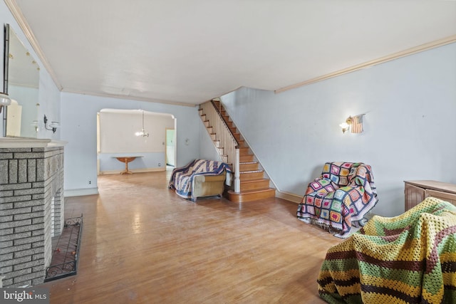 living room with crown molding, hardwood / wood-style floors, and a chandelier