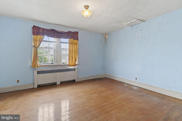 empty room with radiator and light wood-type flooring