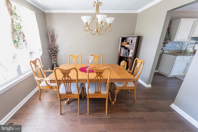 dining room with a chandelier, dark hardwood / wood-style floors, crown molding, and a healthy amount of sunlight