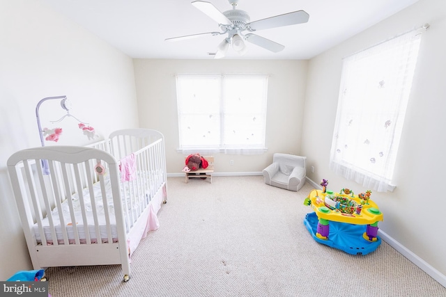 bedroom featuring carpet flooring, ceiling fan, and a crib