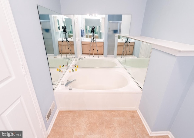 bathroom with vanity, tile patterned floors, and a tub