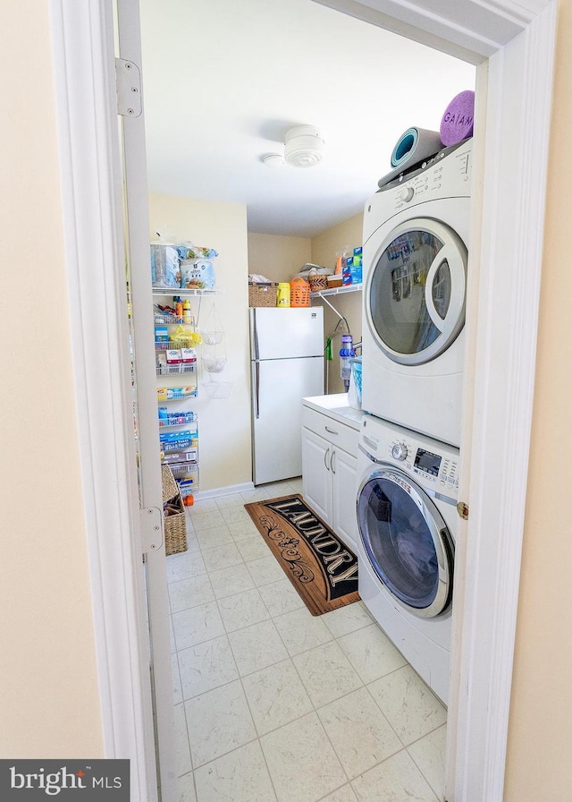 laundry room with cabinets and stacked washer and dryer