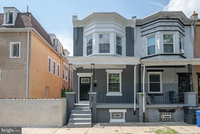 townhome / multi-family property featuring covered porch