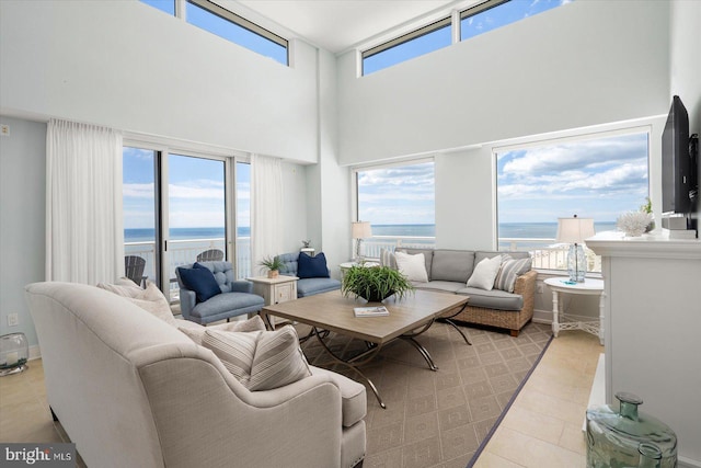 living room featuring a high ceiling, a water view, and a wealth of natural light