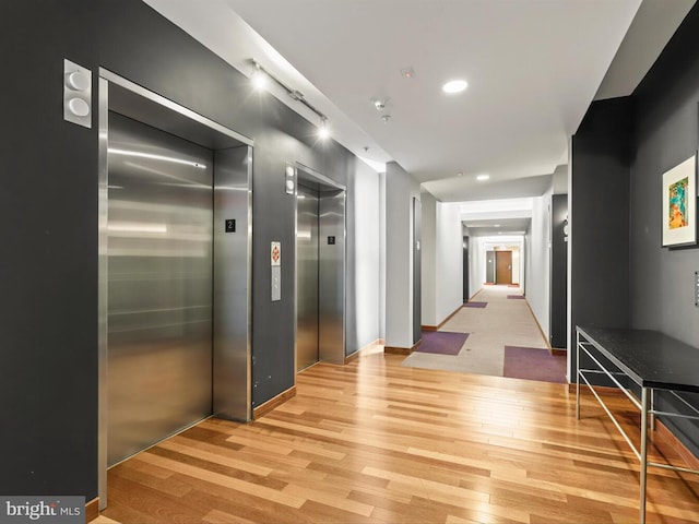 hallway featuring elevator and light wood-type flooring