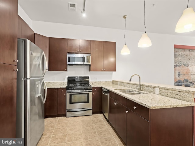 kitchen with kitchen peninsula, appliances with stainless steel finishes, decorative light fixtures, and sink