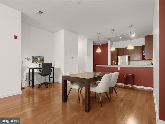 dining space with light wood-type flooring and sink