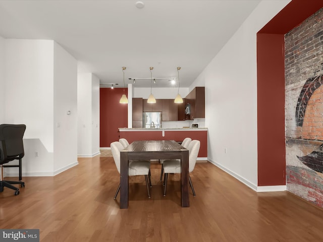 dining room featuring wood-type flooring and rail lighting