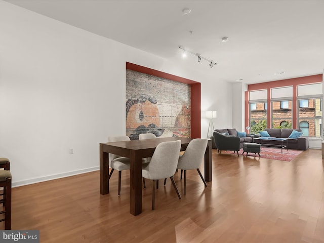 dining room with track lighting and hardwood / wood-style flooring