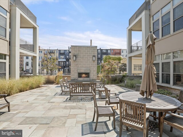 view of patio featuring an outdoor brick fireplace