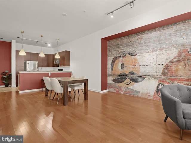 dining space featuring track lighting and light hardwood / wood-style flooring