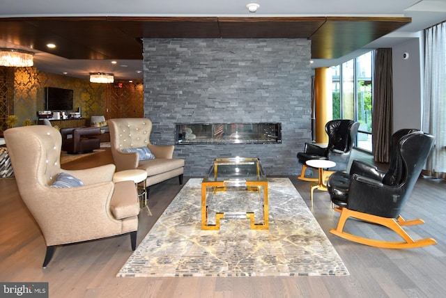 living room with a stone fireplace and hardwood / wood-style flooring