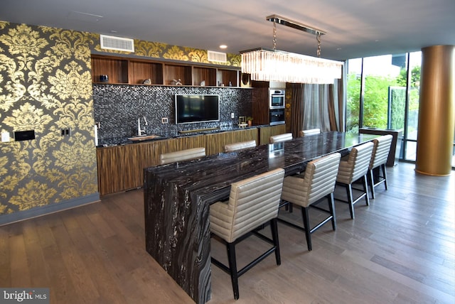 kitchen featuring hanging light fixtures, dark hardwood / wood-style flooring, tasteful backsplash, and rail lighting