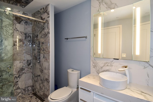 bathroom featuring decorative backsplash, a shower with shower door, toilet, and vanity