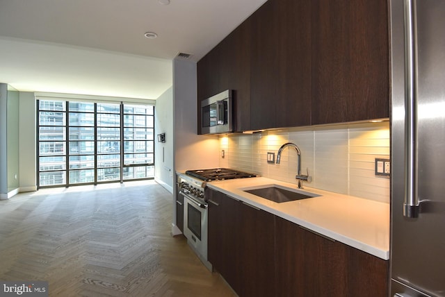 kitchen with tasteful backsplash, stainless steel appliances, light parquet flooring, dark brown cabinetry, and sink