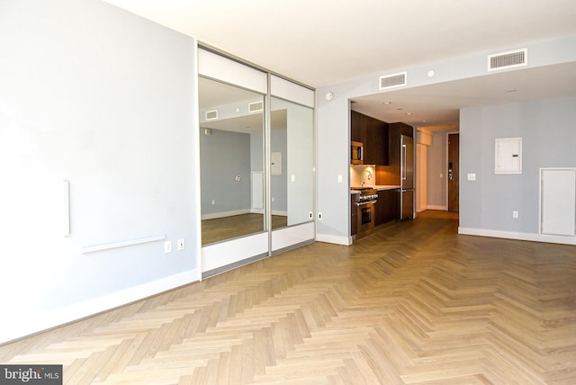 spare room with light parquet floors and electric panel