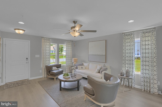 living room with light hardwood / wood-style flooring, a healthy amount of sunlight, and ceiling fan