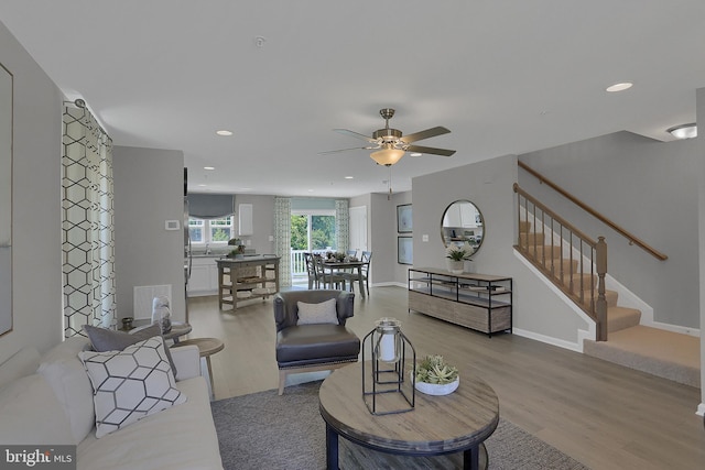 living room with ceiling fan and light wood-type flooring