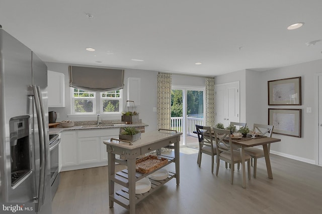 kitchen featuring plenty of natural light, sink, light wood-type flooring, and stainless steel appliances