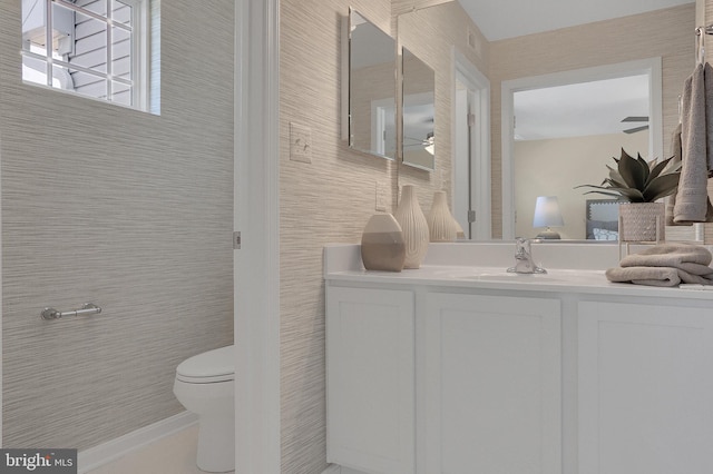 bathroom featuring vanity, tile walls, ceiling fan, and toilet