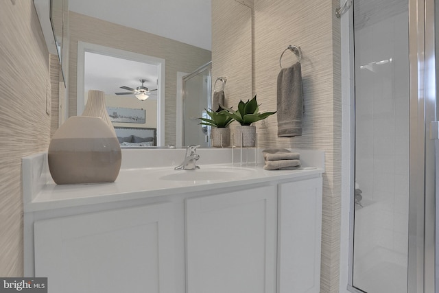 bathroom featuring a shower with shower door, vanity, and ceiling fan