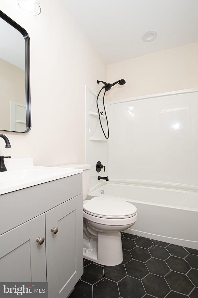 full bathroom featuring vanity, tile patterned flooring, washtub / shower combination, and toilet