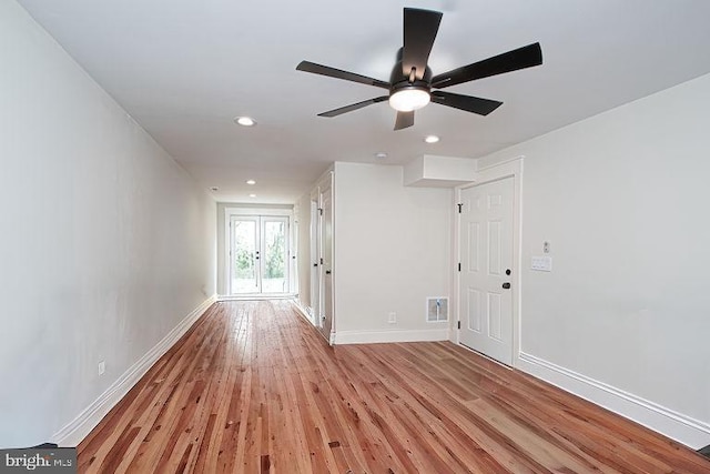 empty room featuring french doors, light wood-type flooring, and ceiling fan