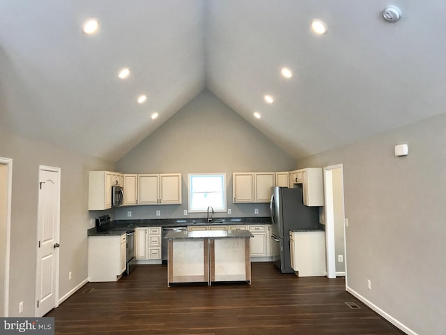 kitchen with a center island, sink, dark wood-type flooring, stainless steel appliances, and high vaulted ceiling