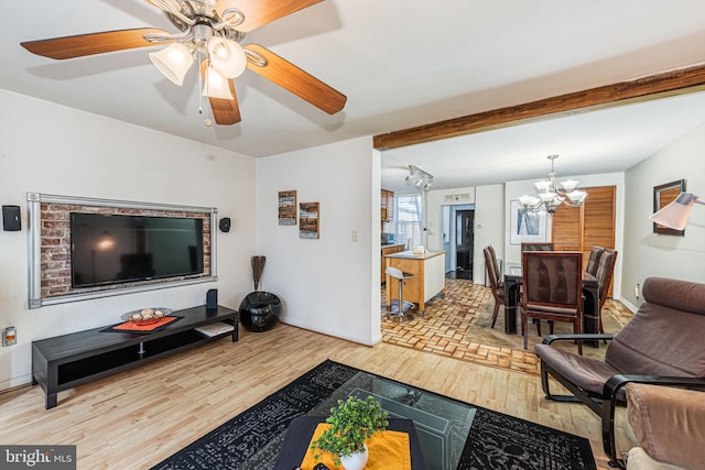 living room featuring ceiling fan with notable chandelier, beamed ceiling, and light hardwood / wood-style flooring