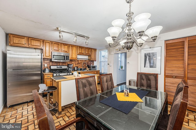 dining room featuring a notable chandelier and rail lighting