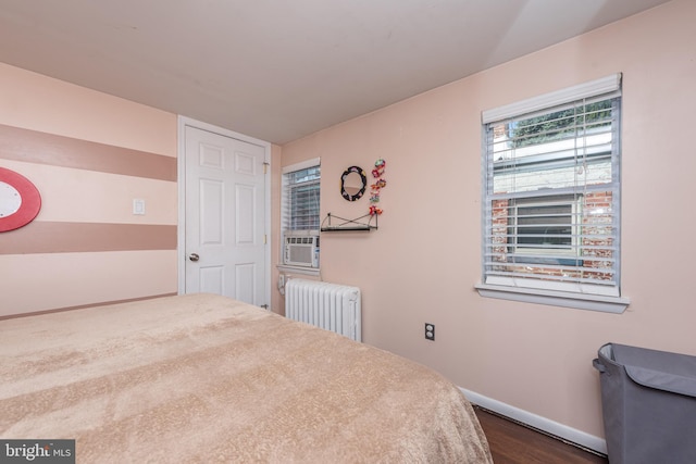 bedroom with radiator and dark hardwood / wood-style flooring