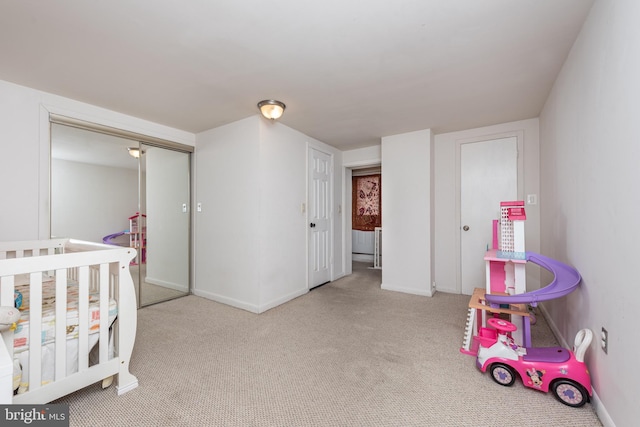 bedroom with carpet floors, a nursery area, and a closet