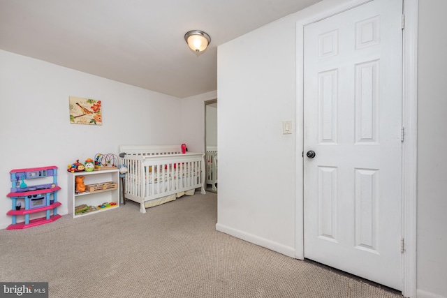 carpeted bedroom with a nursery area