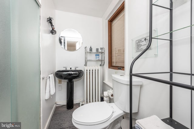 bathroom featuring toilet, sink, and radiator heating unit