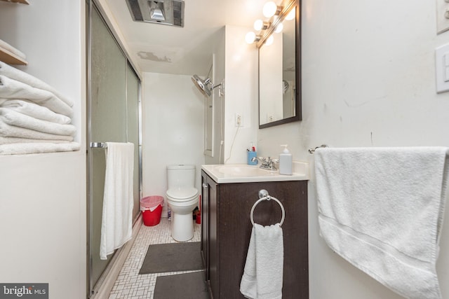 bathroom with vanity, toilet, a shower with door, and tile patterned flooring