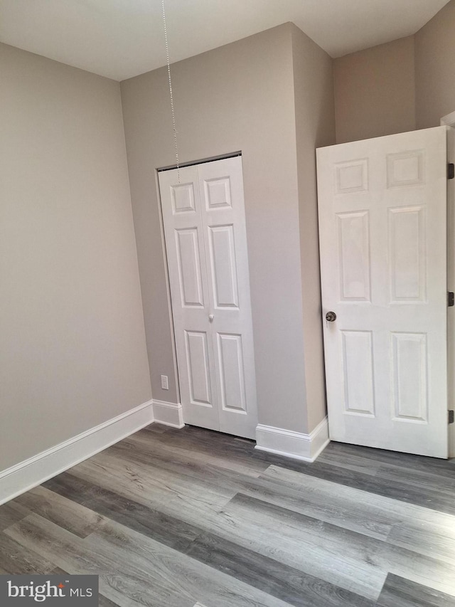 unfurnished bedroom featuring hardwood / wood-style flooring and a closet