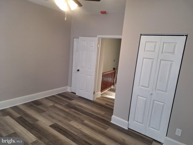 unfurnished bedroom with dark hardwood / wood-style floors, ceiling fan, and a closet