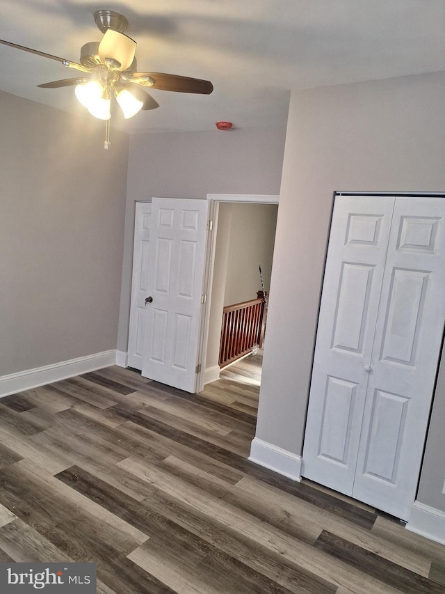 empty room with ceiling fan and dark hardwood / wood-style floors