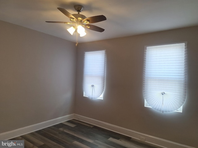 empty room with dark hardwood / wood-style flooring, plenty of natural light, and ceiling fan