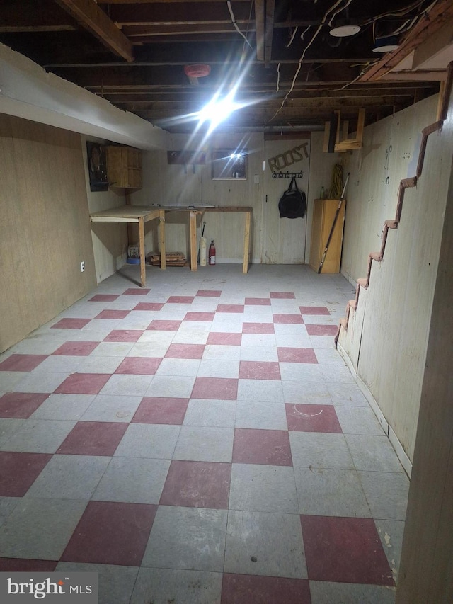 basement featuring wooden walls