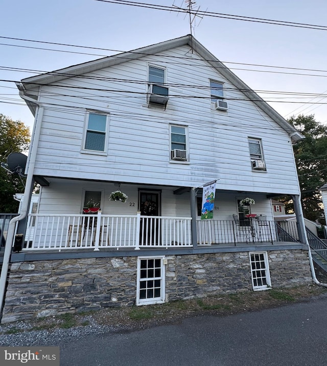 view of front of property with a porch and cooling unit