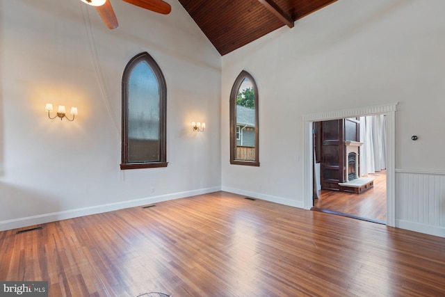 unfurnished room with ceiling fan, beamed ceiling, high vaulted ceiling, wood ceiling, and hardwood / wood-style flooring