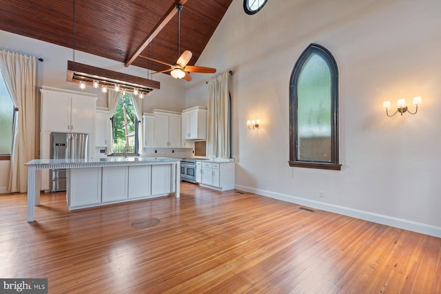 kitchen featuring wooden ceiling, white cabinets, decorative backsplash, a kitchen island, and stainless steel appliances