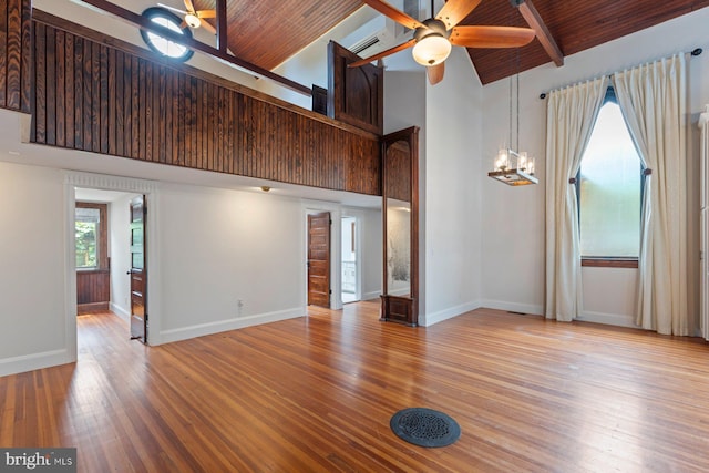 unfurnished living room featuring wood ceiling, ceiling fan with notable chandelier, beam ceiling, high vaulted ceiling, and light hardwood / wood-style floors