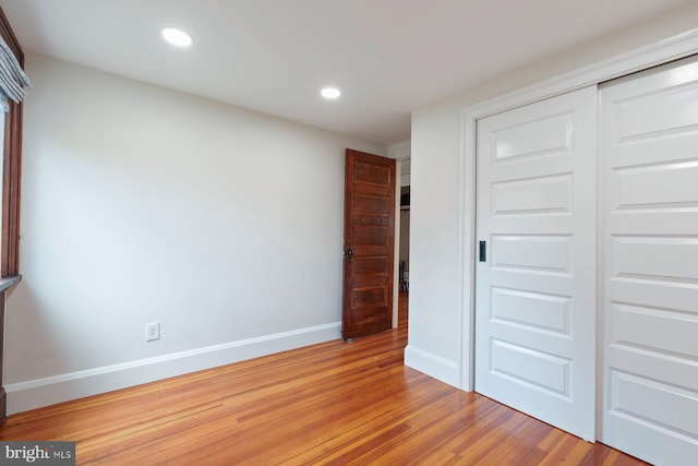 unfurnished bedroom featuring light hardwood / wood-style floors and a closet