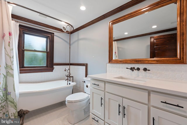 bathroom featuring vanity, tile patterned floors, crown molding, toilet, and a tub to relax in