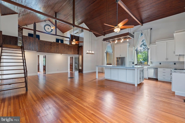 kitchen with a kitchen island, ceiling fan, high vaulted ceiling, dishwasher, and white cabinetry