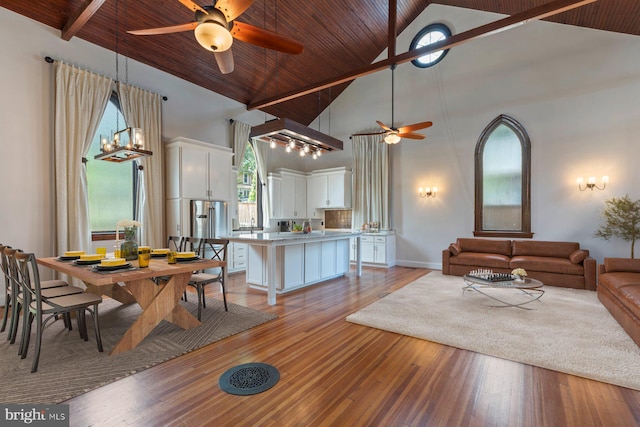 living room featuring high vaulted ceiling, light hardwood / wood-style flooring, ceiling fan, beam ceiling, and wood ceiling