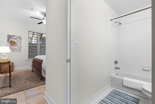 bathroom featuring tile patterned flooring, tiled shower / bath combo, and toilet